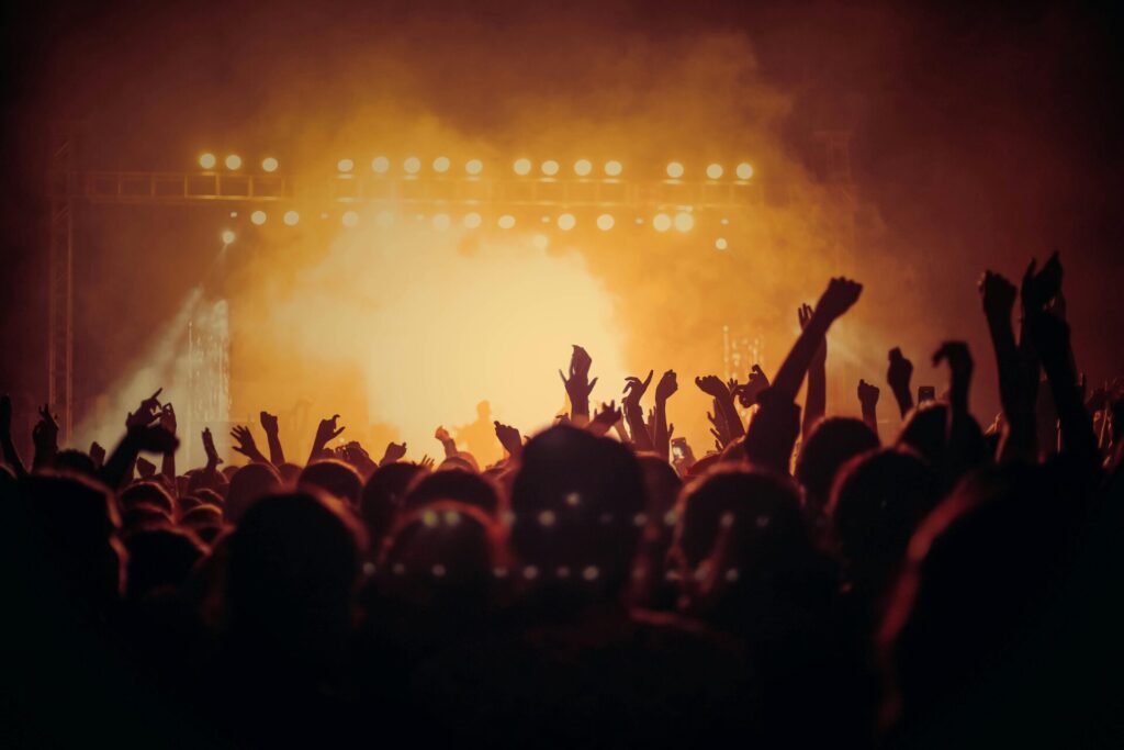 Crowd enjoying a live concert at sunset with vibrant stage lighting at the 4Peaks Music Festival